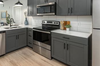 Kitchen with stainless steel stove and white backsplash